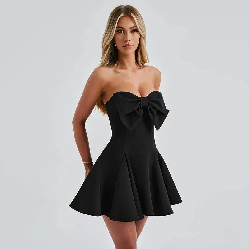 Modelo usando vestido corto negro con moño elegante, ideal para boda civil