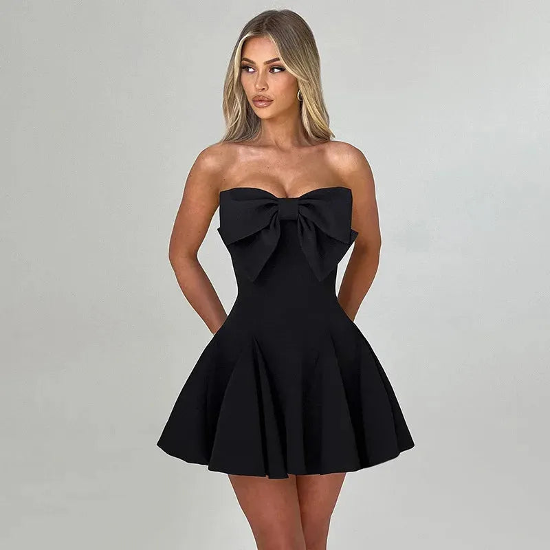 Modelo usando vestido corto negro con moño elegante, ideal para boda civil