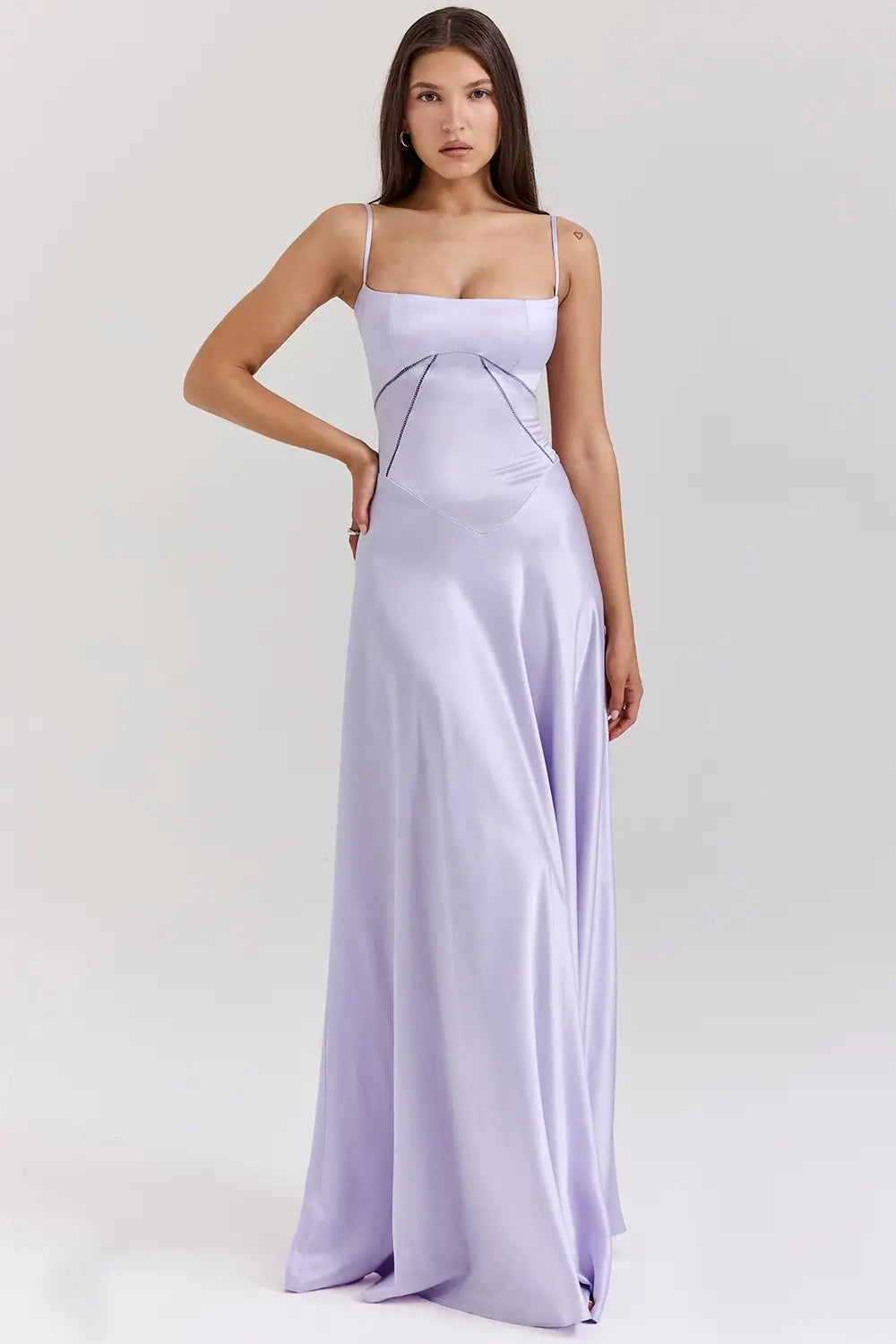 Vestido largo lila elegante para mujer con espalda descubierta y detalle de encaje delicado, ideal para bodas, fiestas formales, cenas especiales y eventos de noche. El modelo Mavie de Veliara está confeccionado en una tela de caída fluida que se adapta al cuerpo con suavidad, realzando la silueta sin apretar. Su escote recto y diseño sin tirantes ofrecen un look sofisticado y sensual, mientras que el encaje en la espalda añade un toque de romanticismo moderno.