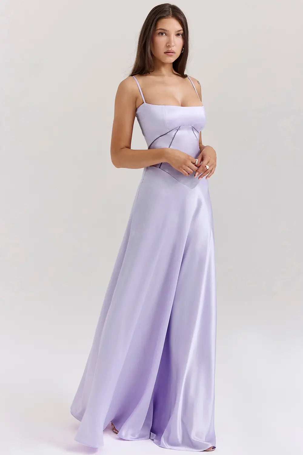 Vestido largo lila elegante para mujer con espalda descubierta y detalle de encaje delicado, ideal para bodas, fiestas formales, cenas especiales y eventos de noche. El modelo Mavie de Veliara está confeccionado en una tela de caída fluida que se adapta al cuerpo con suavidad, realzando la silueta sin apretar. Su escote recto y diseño sin tirantes ofrecen un look sofisticado y sensual, mientras que el encaje en la espalda añade un toque de romanticismo moderno.
