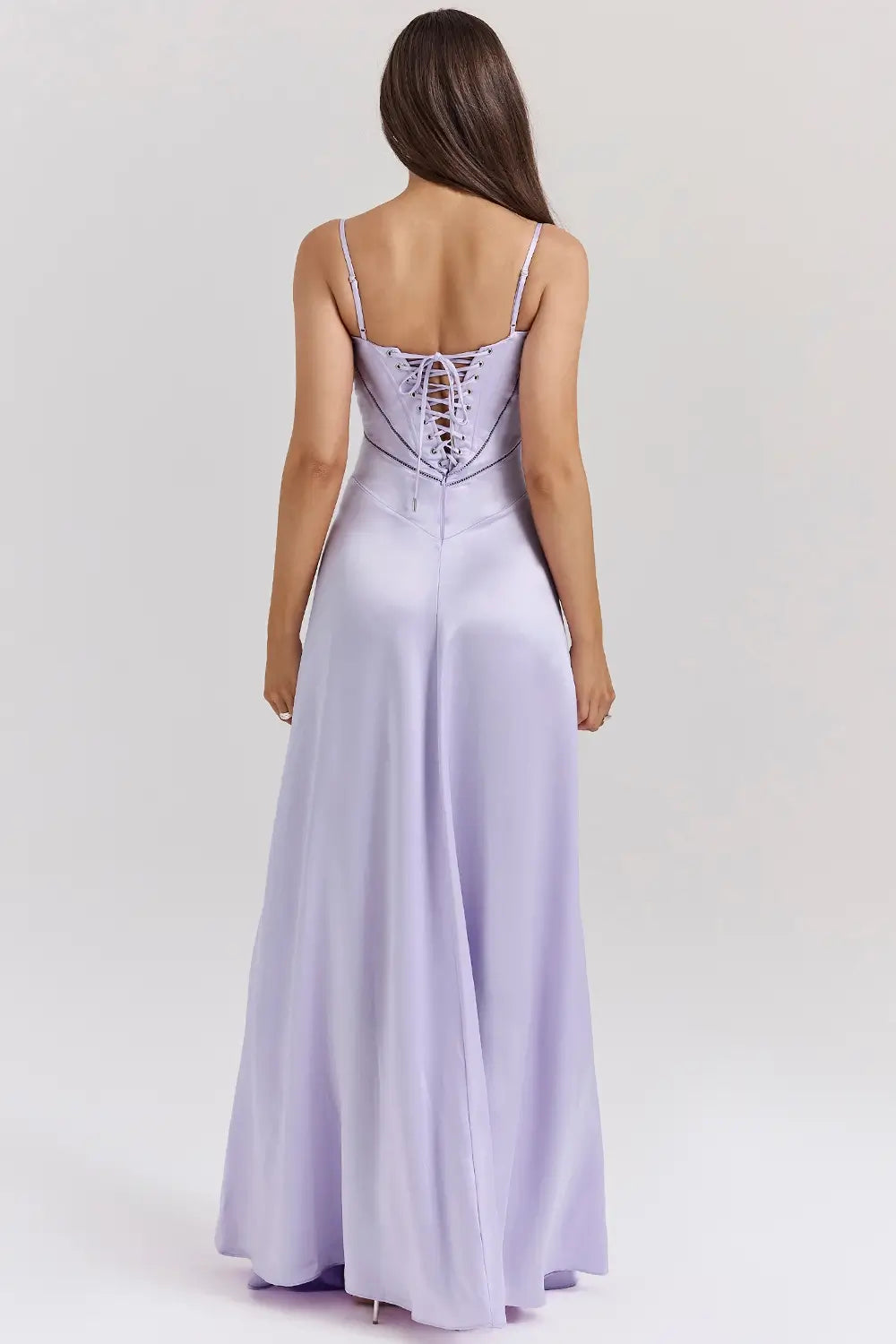 Vestido largo lila elegante para mujer con espalda descubierta y detalle de encaje delicado, ideal para bodas, fiestas formales, cenas especiales y eventos de noche. El modelo Mavie de Veliara está confeccionado en una tela de caída fluida que se adapta al cuerpo con suavidad, realzando la silueta sin apretar. Su escote recto y diseño sin tirantes ofrecen un look sofisticado y sensual, mientras que el encaje en la espalda añade un toque de romanticismo moderno.