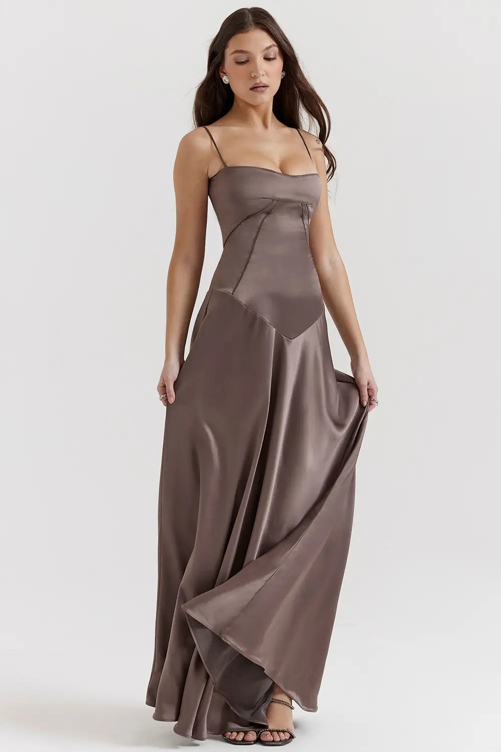 Vestido largo marron elegante para mujer con espalda descubierta y detalle de encaje delicado, ideal para bodas, fiestas formales, cenas especiales y eventos de noche. El modelo Mavie de Veliara está confeccionado en una tela de caída fluida que se adapta al cuerpo con suavidad, realzando la silueta sin apretar. Su escote recto y diseño sin tirantes ofrecen un look sofisticado y sensual, mientras que el encaje en la espalda añade un toque de romanticismo moderno.