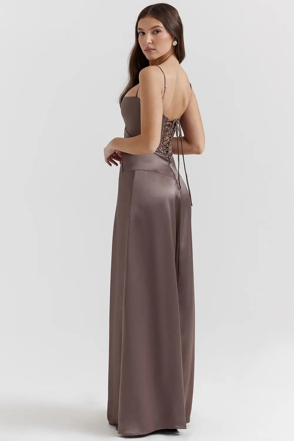 Vestido largo marron elegante para mujer con espalda descubierta y detalle de encaje delicado, ideal para bodas, fiestas formales, cenas especiales y eventos de noche. El modelo Mavie de Veliara está confeccionado en una tela de caída fluida que se adapta al cuerpo con suavidad, realzando la silueta sin apretar. Su escote recto y diseño sin tirantes ofrecen un look sofisticado y sensual, mientras que el encaje en la espalda añade un toque de romanticismo moderno.