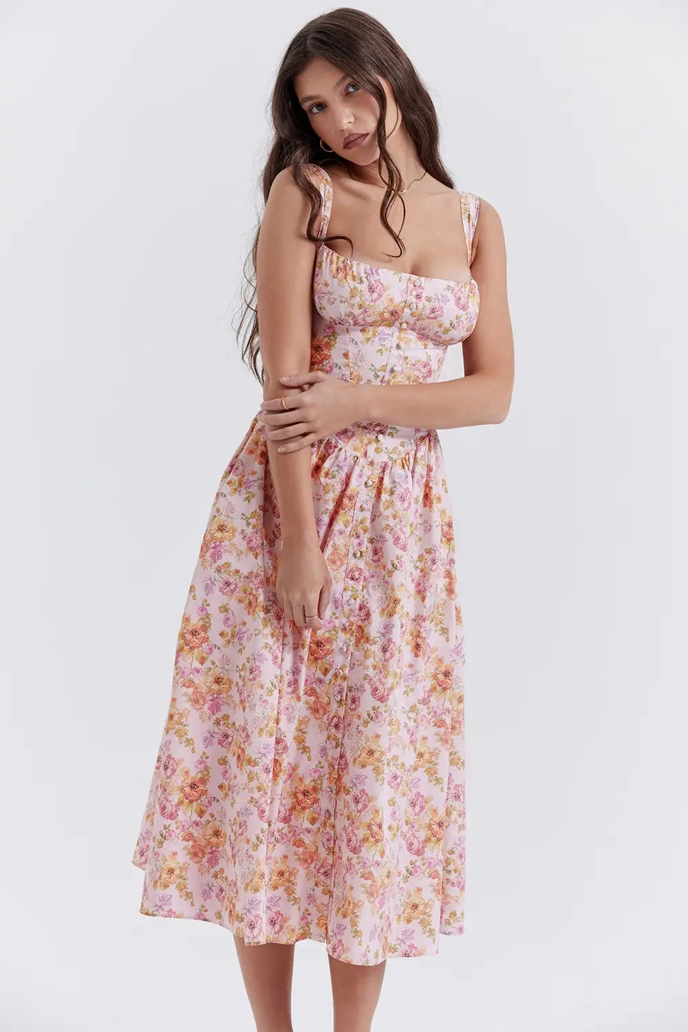 Modelo usando vestido midi color rosa con corset estructurado y falda con volumen.