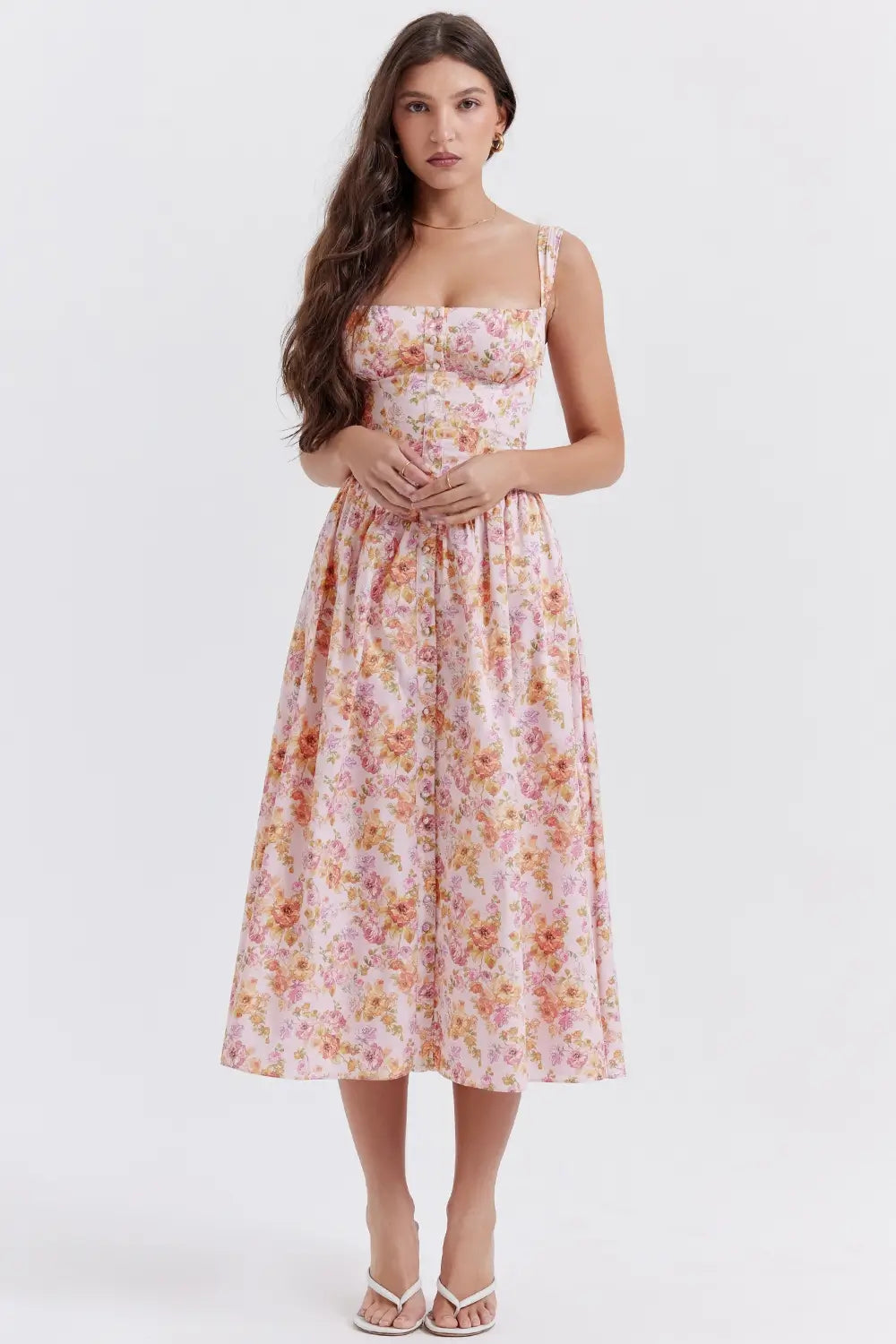 Modelo usando vestido midi color rosa con corset estructurado y falda con volumen.
