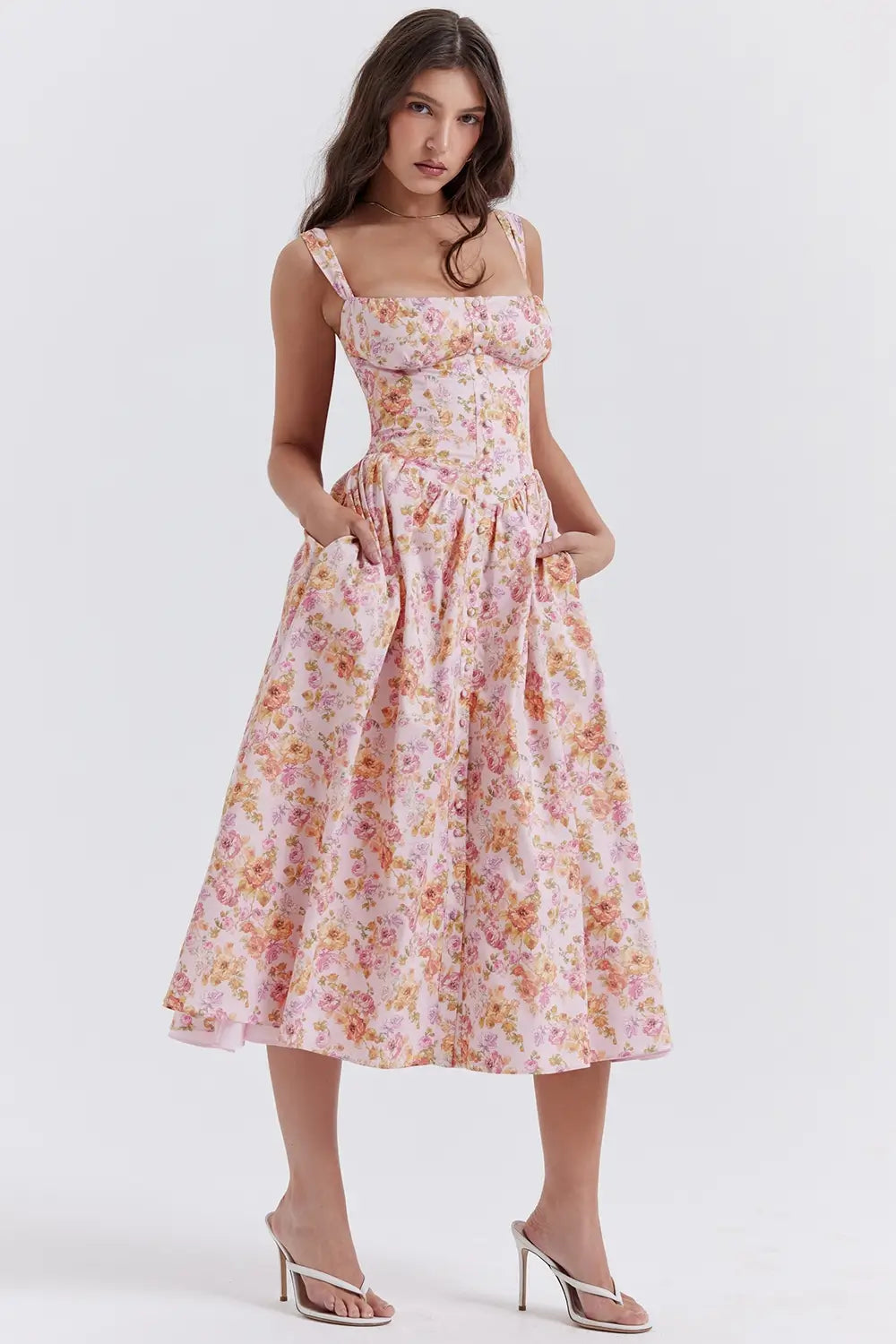 Modelo usando vestido midi color rosa con corset estructurado y falda con volumen.