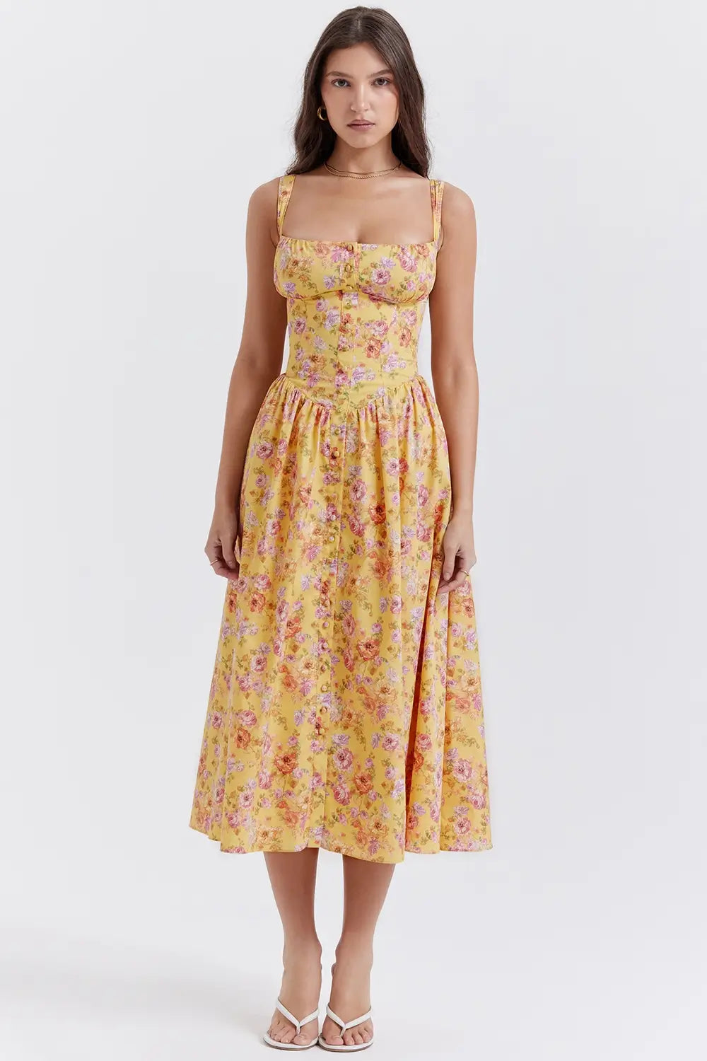 Modelo usando vestido midi color amarillo con corset estructurado y falda con volumen.