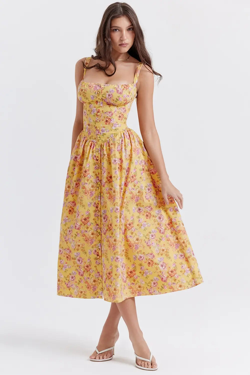 Modelo usando vestido midi color amarillo con corset estructurado y falda con volumen.