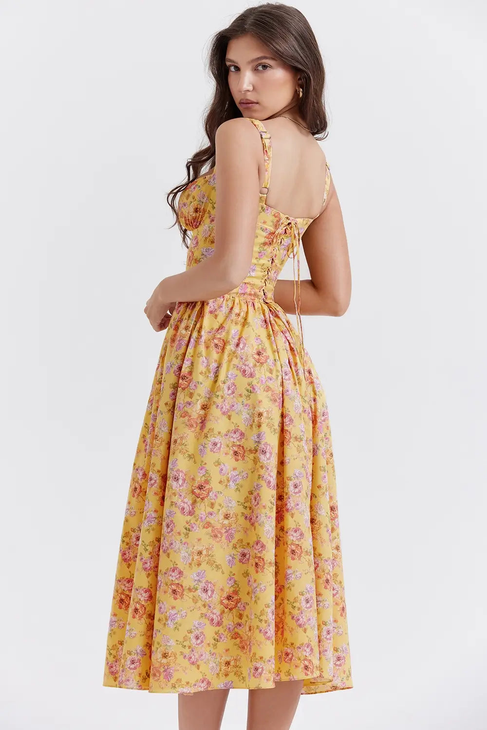 Modelo usando vestido midi color amarillo con corset estructurado y falda con volumen.