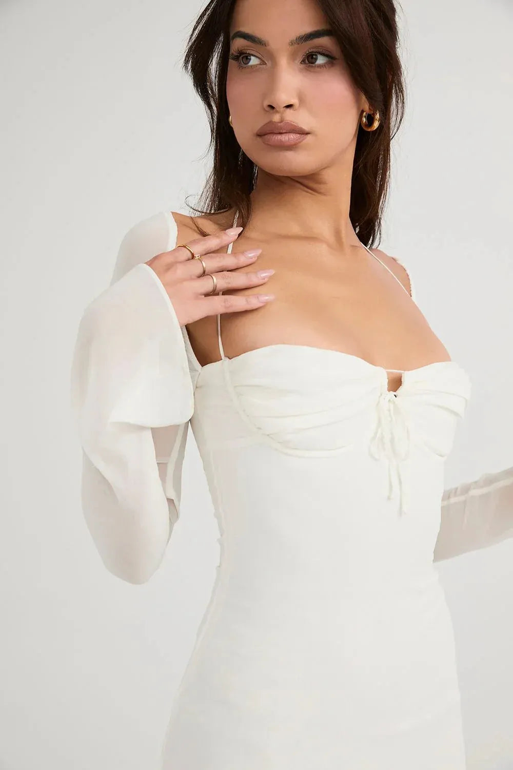 Modelo usando vestido blanco corto Mini Olivia con tirantes finos en jardín elegante