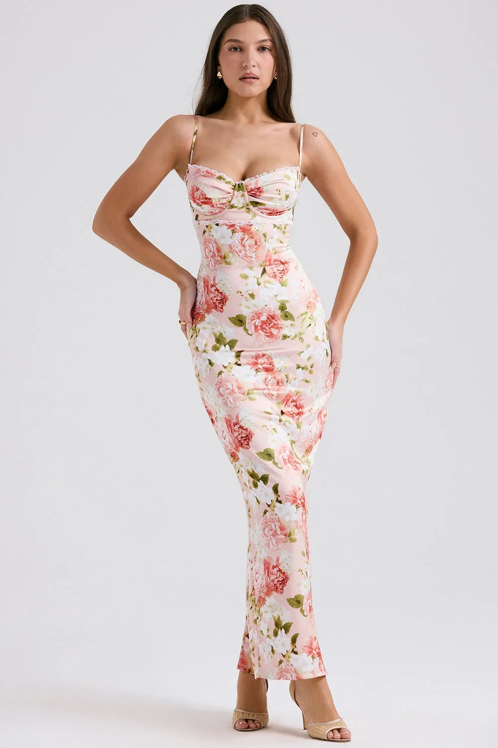 Modelo usando vestido largo floral ajustado al cuerpo con tirantes finos, ideal para fiestas y bodas.