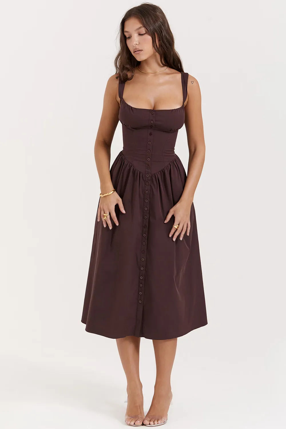Modelo usando vestido midi color marrón con corset estructurado y falda con volumen.
