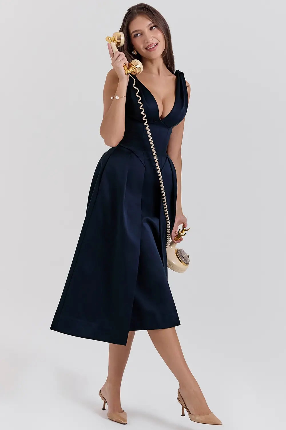 Modelo usando vestido midi plisado de satén azul marino – ideal para bodas y eventos especiales