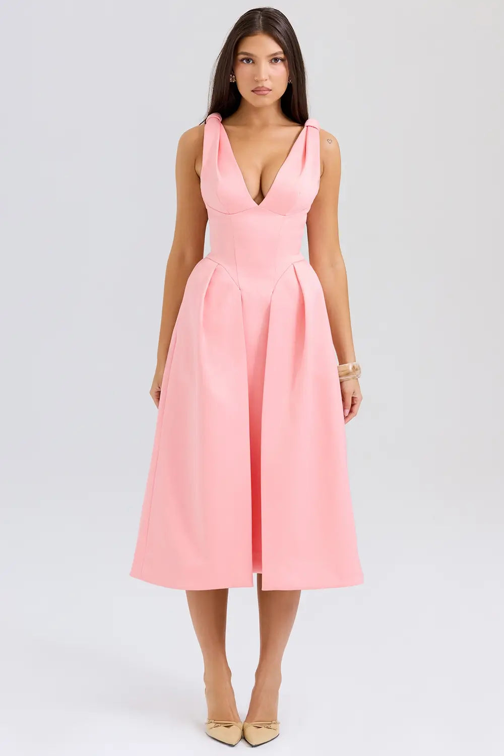 Modelo usando vestido midi rosa de satén plisado – diseño sofisticado con lazos y falda estructurada