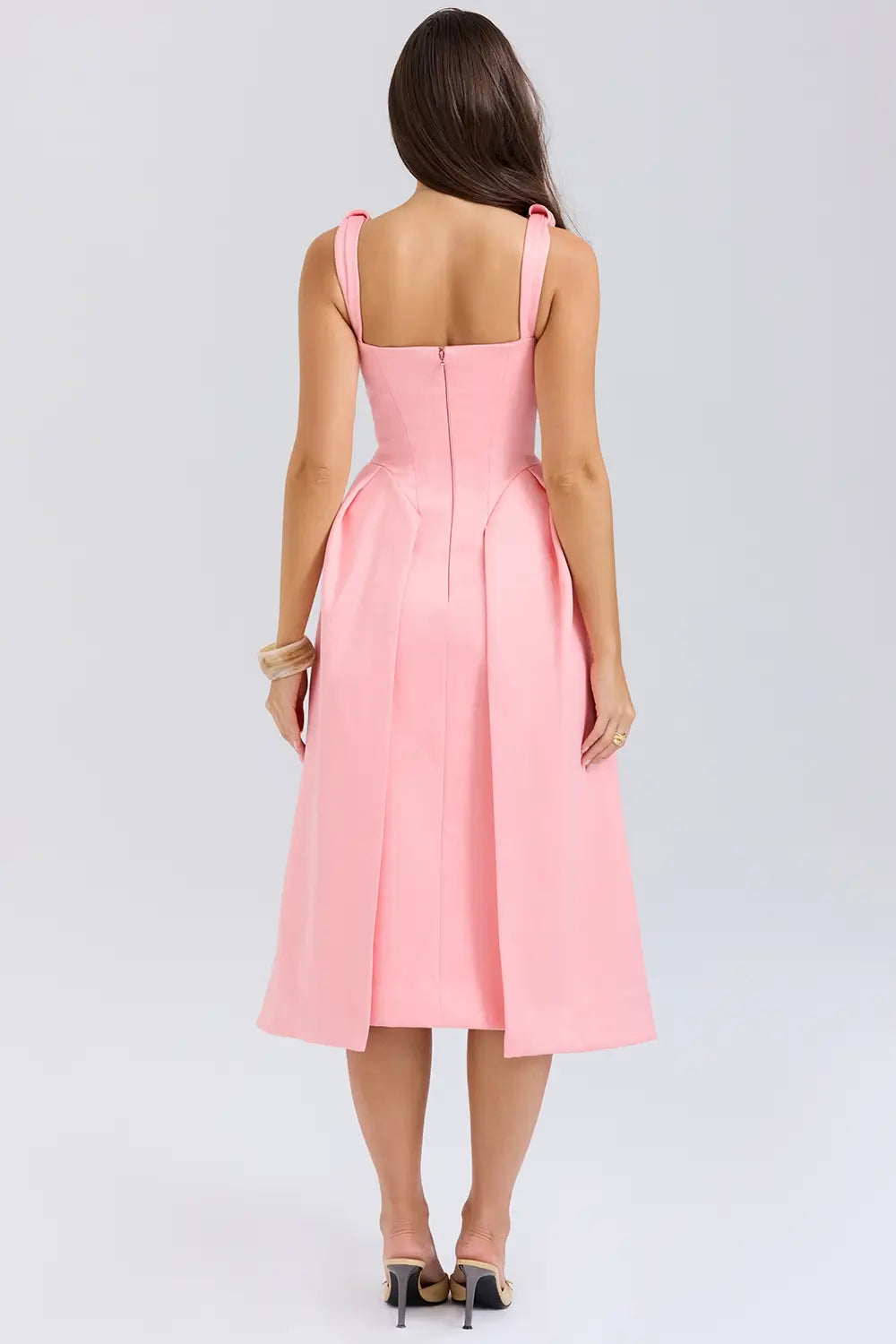 Modelo usando vestido midi rosa de satén plisado – diseño sofisticado con lazos y falda estructurada
