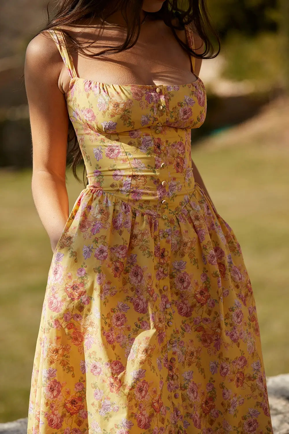 Modelo usando vestido midi color amarillo con corset estructurado y falda con volumen.
